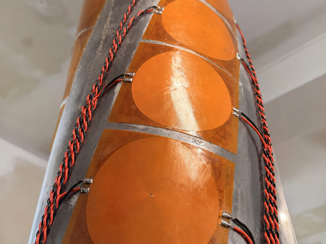 A HELIX sensor wrap conformed and strapped to a pipe section, with its sensing elements against the wall